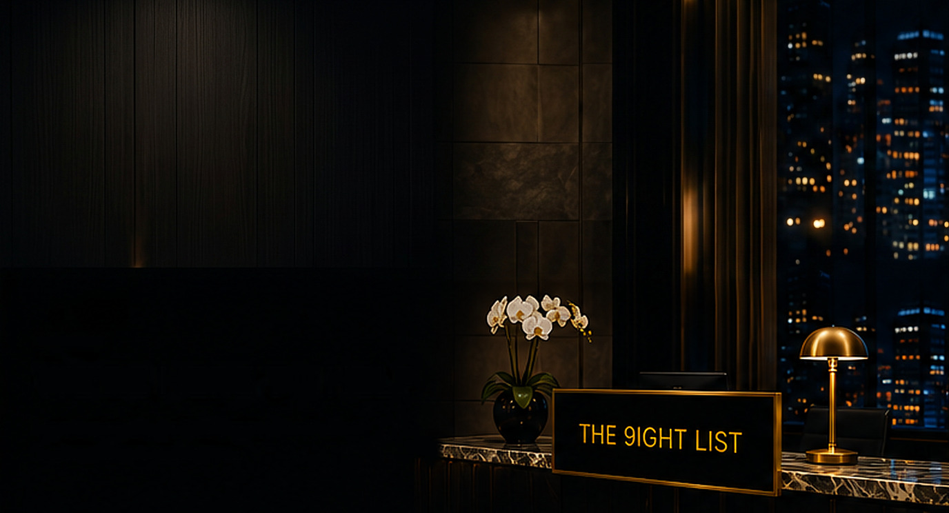 Concierge reception desk with an orchid, a brass lamp and a THE 9IGHT LIST plaque